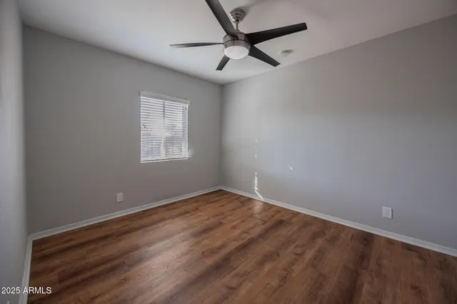an empty room with a window and a fan