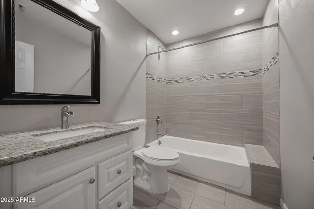 a bathroom with a granite countertop sink a toilet and bathtub