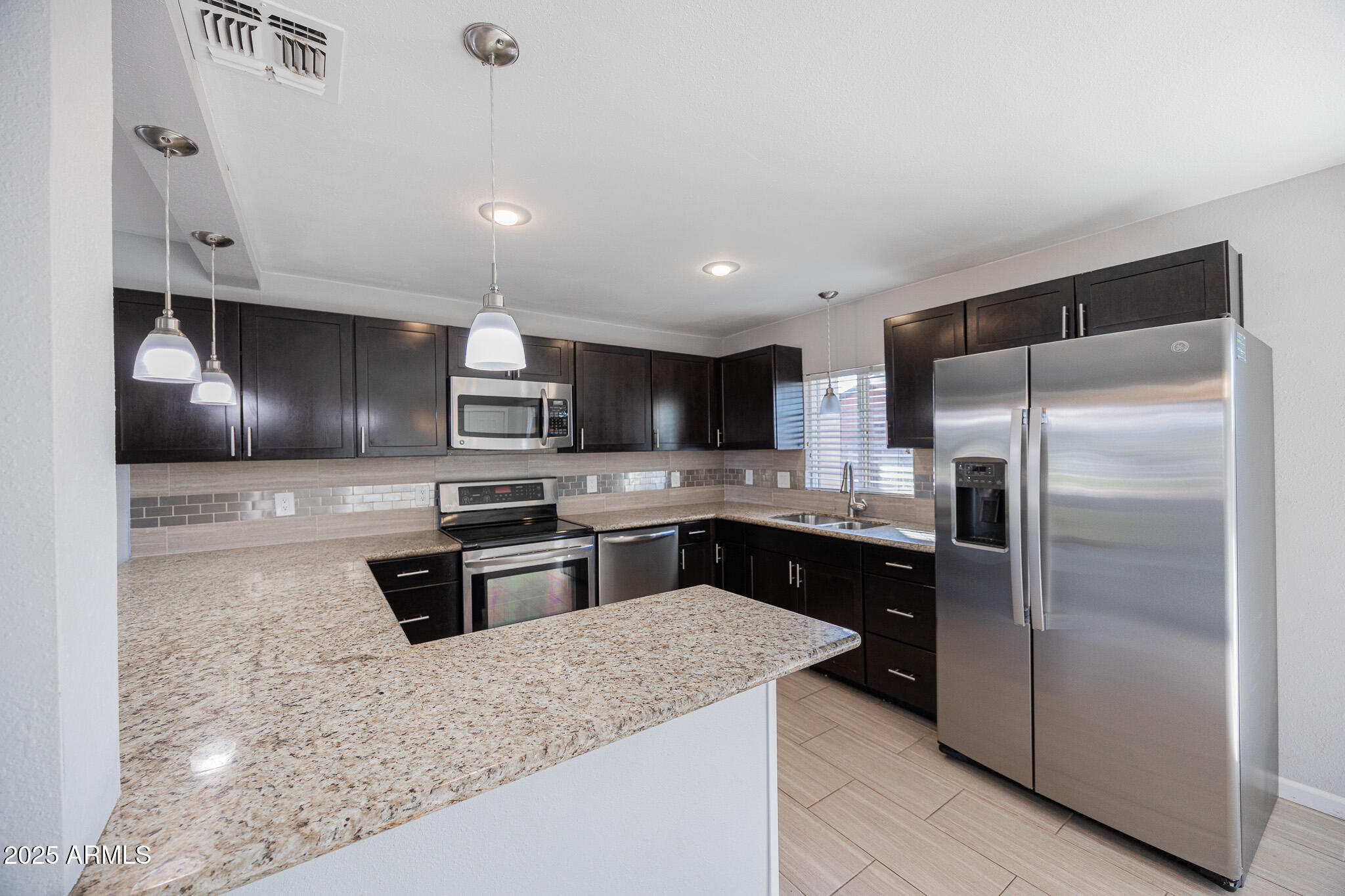 1619 East Whitton Avenue Phoenix, AZ 85016 - Photo 7 of 22 a kitchen with stainless steel appliances granite countertop a refrigerator a sink a stove and oven