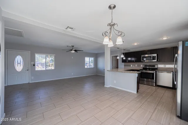 a view of kitchen with sink microwave and stove top oven