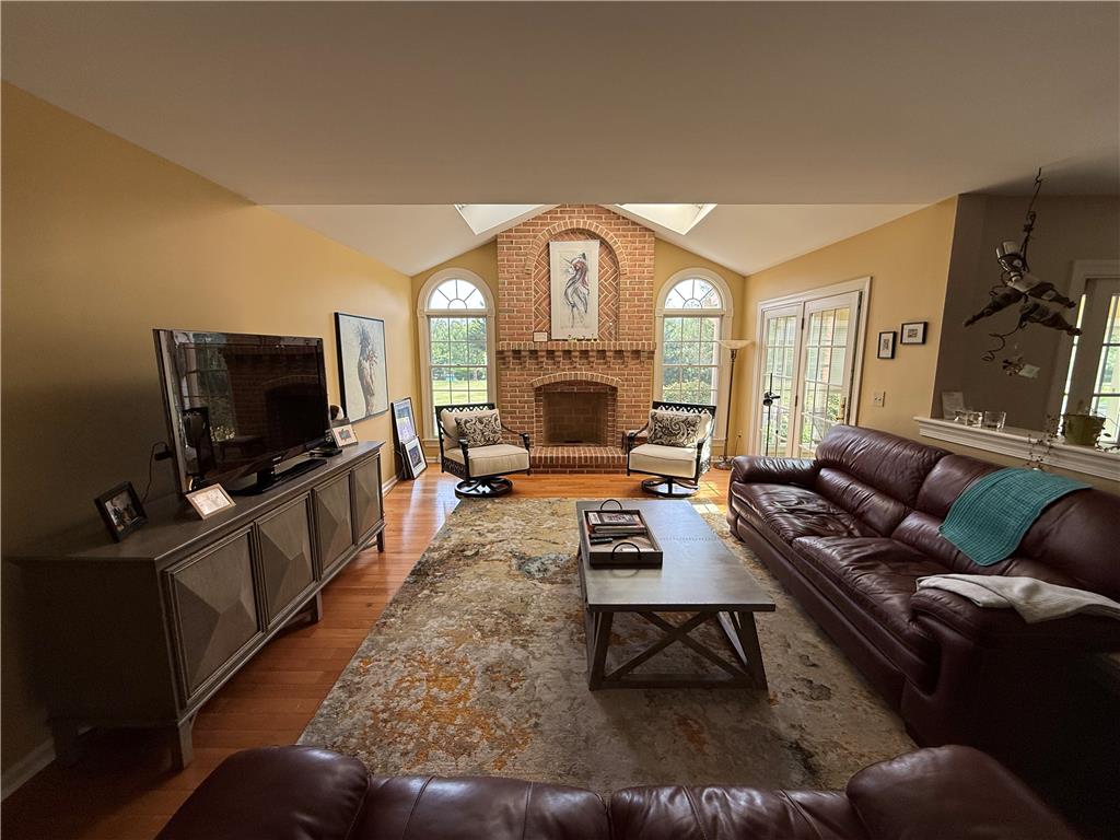4114 Rochelle Drive Allentown, PA 18104 - Photo 9 of 35 A well-lit living space features a commanding brick fireplace with arched windows and hardwood flooring.