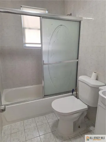 a white toilet sitting next to a bath tub and shower