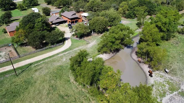 an aerial view of a house with a yard and lake view