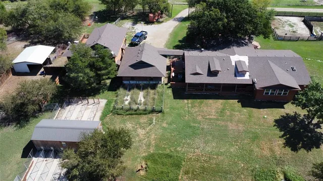 an aerial view of a house with garden space and a patio