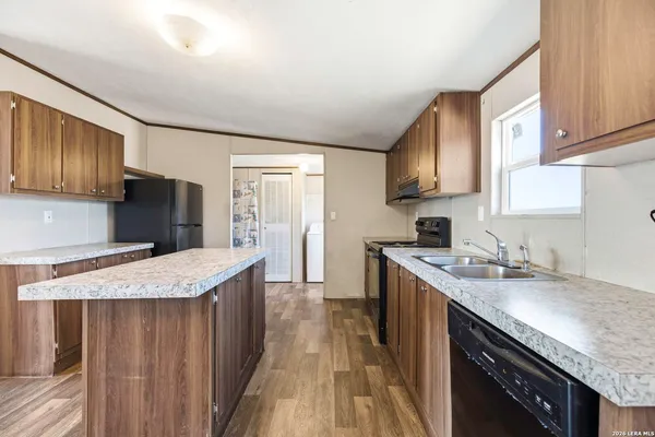 a kitchen with granite countertop a stove top oven and cabinets