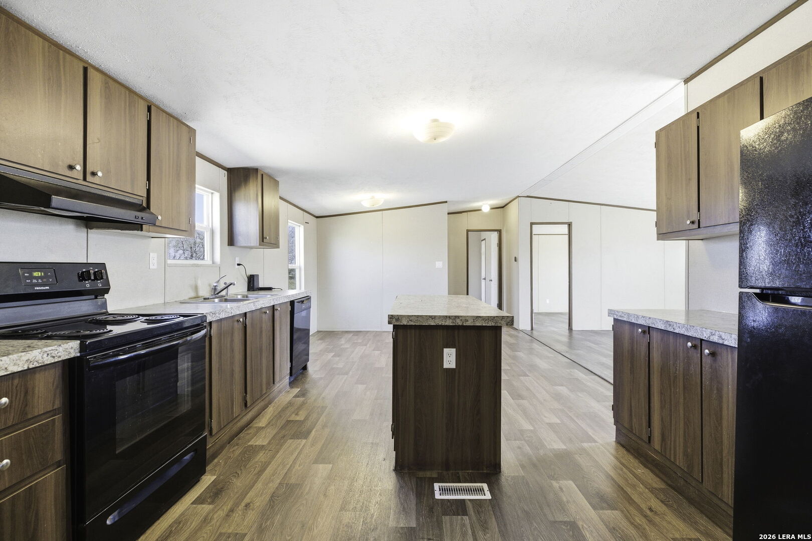 393 West County Road 5719 Devine, TX 78016 - Photo 12 of 26 a kitchen with granite countertop a stove top oven and cabinets