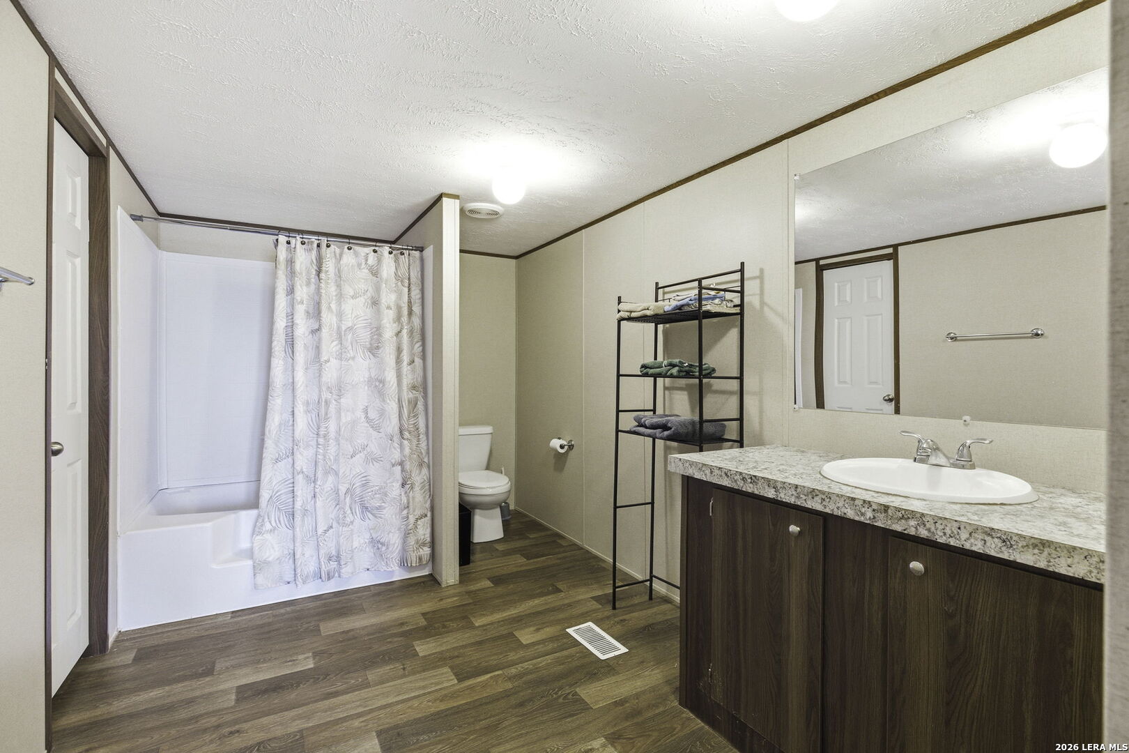 393 West County Road 5719 Devine, TX 78016 - Photo 14 of 26 a spacious bathroom with a granite countertop sink mirror and a shower
