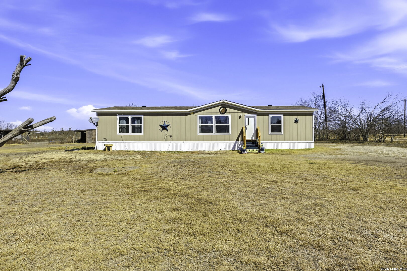 393 West County Road 5719 Devine, TX 78016 - Photo 2 of 26 a house view with a swimming pool