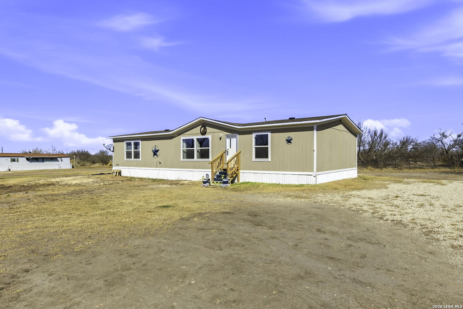 393 West County Road 5719 Devine, TX 78016 - Photo 3 of 26 a view of house with backyard space and yard