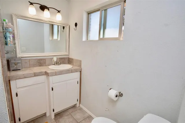 a bathroom with a sink vanity and mirror