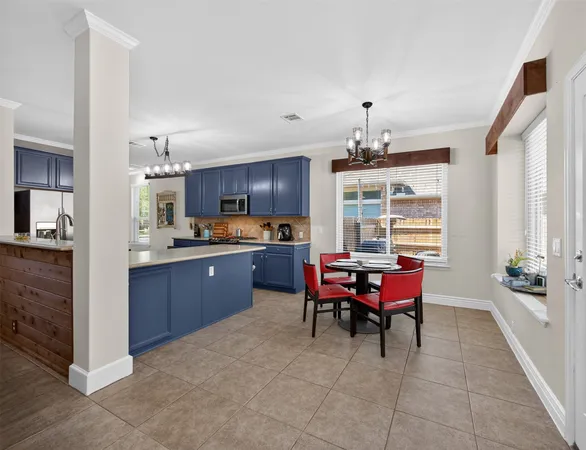 a kitchen with a dining table chairs stainless steel appliances and cabinets