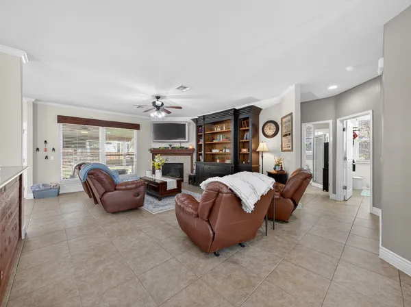 a living room with furniture a fireplace and wall paintings