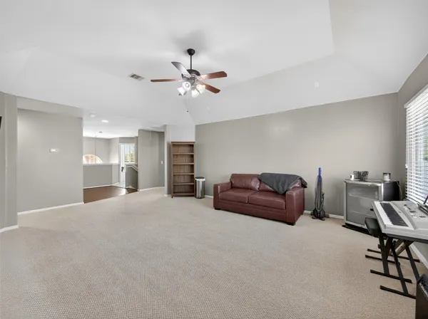 a spacious bedroom with a bed a couch and a chandelier