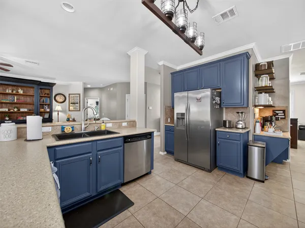 a kitchen with stainless steel appliances granite countertop a refrigerator a sink dishwasher stove and oven