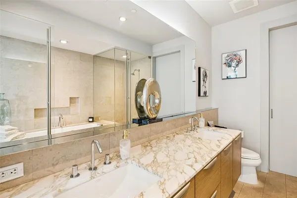 a spacious bathroom with a tub sink and mirror