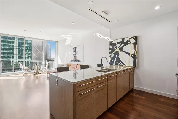 a kitchen with stainless steel appliances a table chairs refrigerator and sink