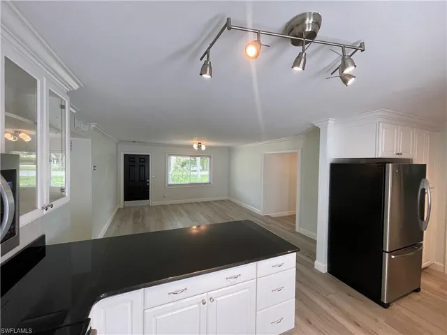 a kitchen with a refrigerator and white cabinets