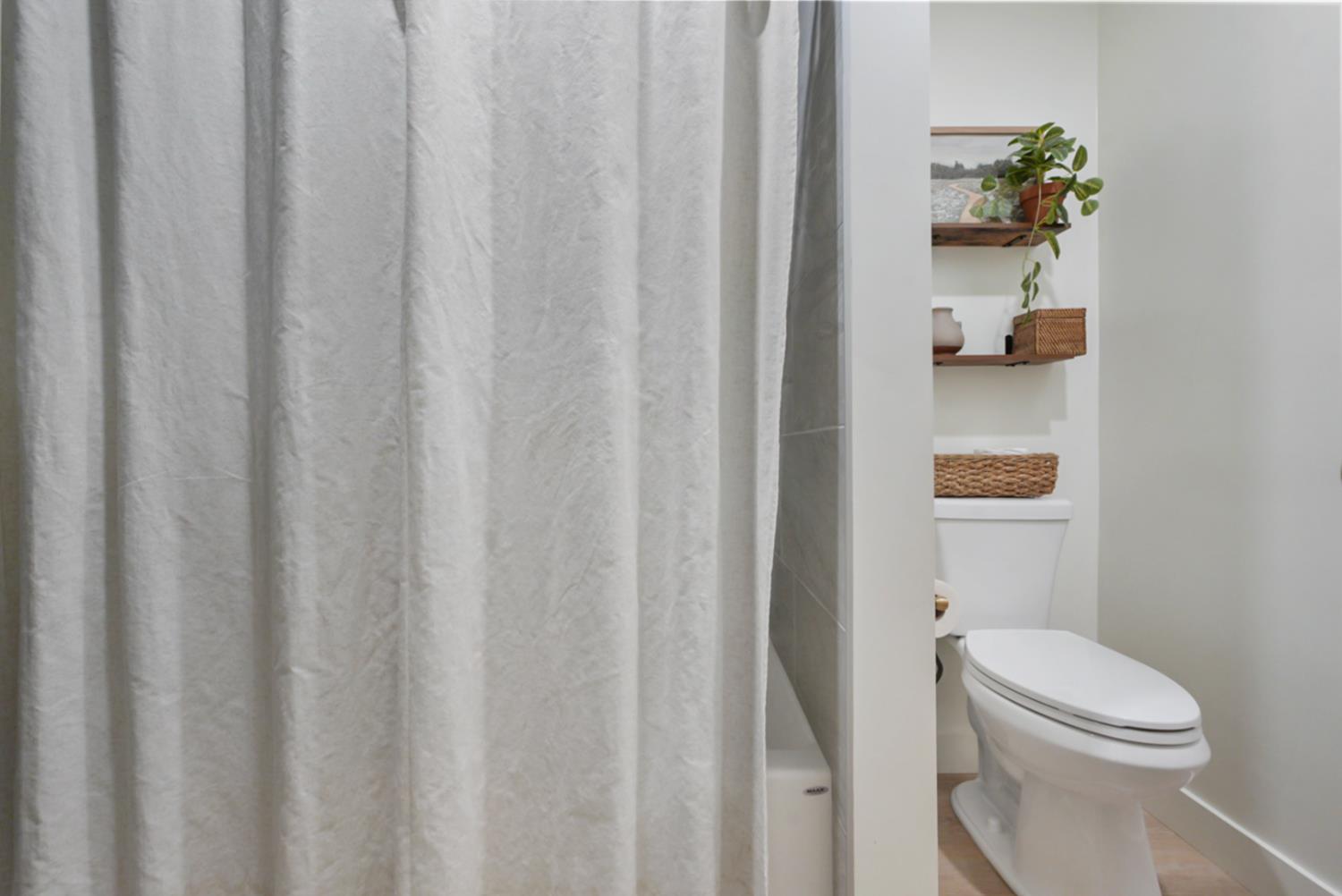 3280 Cheyenne Drive Merced, CA 95348 - Photo 15 of 17 a bathroom with a toilet and a shower curtain