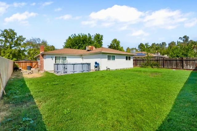 a view of a house with a big yard and large trees