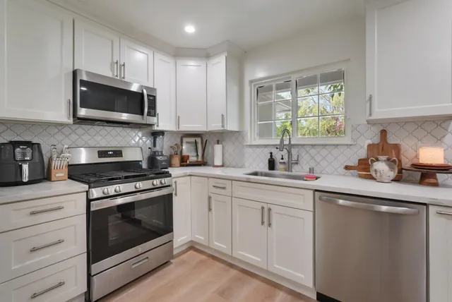 a kitchen with white cabinets stainless steel appliances and sink