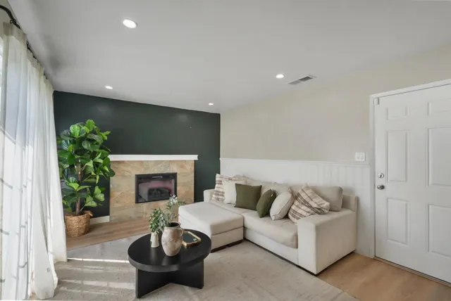a living room with furniture a fireplace and a potted plant