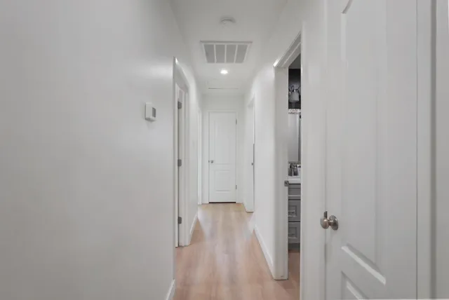a view of a hallway with wooden floor and staircase