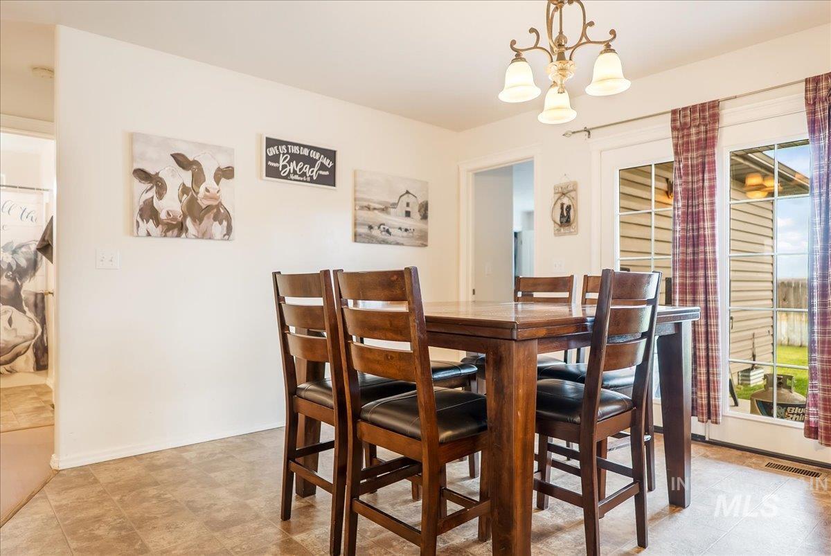 215 Little Cedar Street Hansen, ID 83334 - Photo 10 of 26 Dining space featuring a chandelier and baseboards