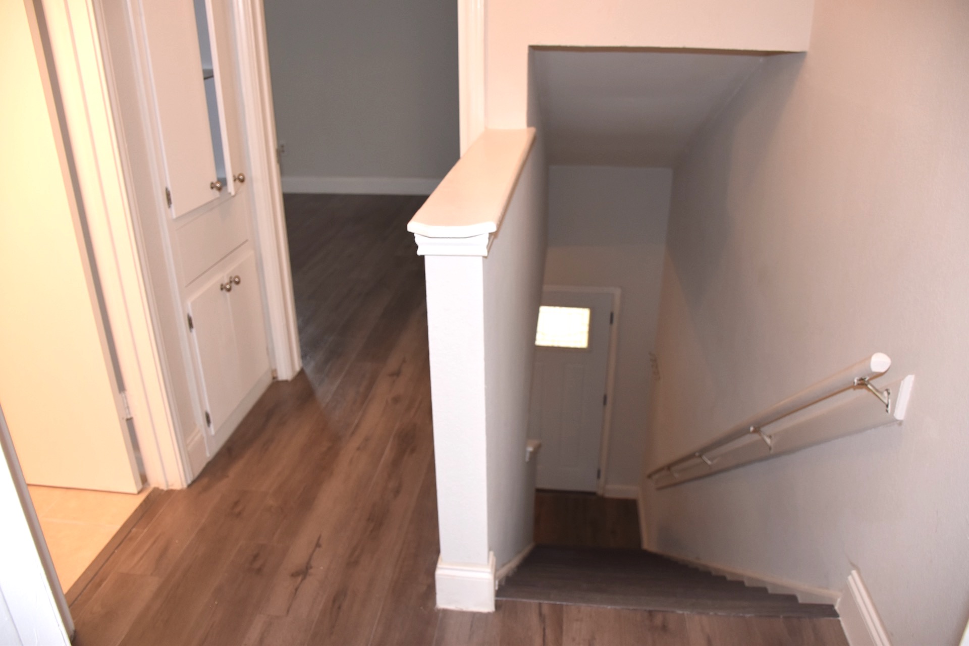 1810 Rawhide Loop Round Rock, TX 78681 - Photo 19 of 29 Stairwell with a white handrail and wood-finish treads leading to a lower level