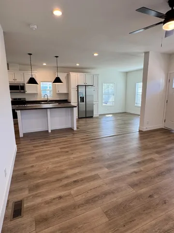 a large kitchen with kitchen island a sink stainless steel appliances and cabinets