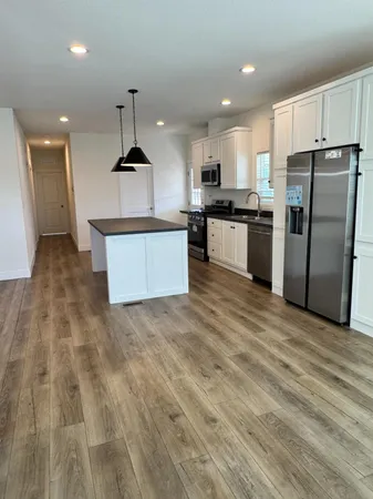 a kitchen with stainless steel appliances kitchen island a refrigerator sink and cabinets