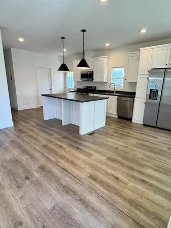 a kitchen with stainless steel appliances granite countertop a sink a stove and a refrigerator