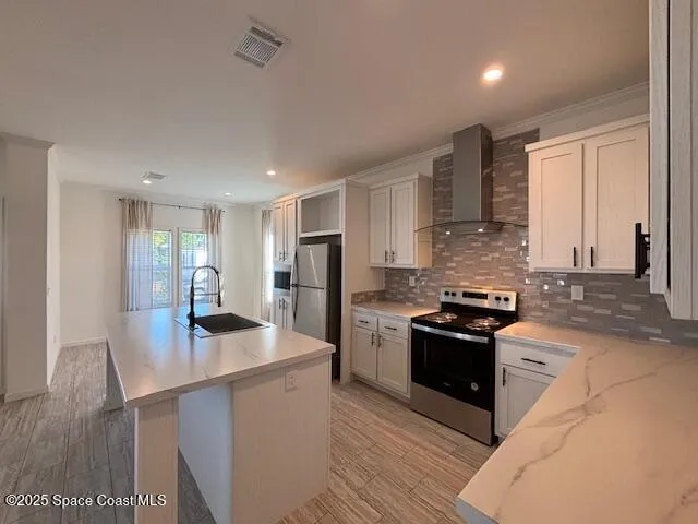 a kitchen with stainless steel appliances granite countertop a stove refrigerator sink and cabinets