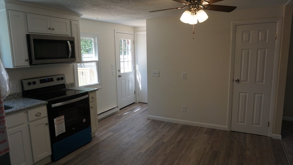 95 Sierra Vista Road Springfield, MA 01128 - Photo 9 of 28 a kitchen with stainless steel appliances granite countertop a stove a microwave and a hard wood floors