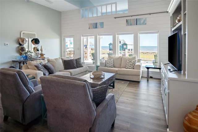 a living room with furniture a flat screen tv and a chandelier