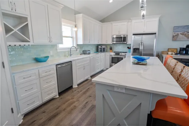 a kitchen with stainless steel appliances granite countertop a sink a stove and a refrigerator