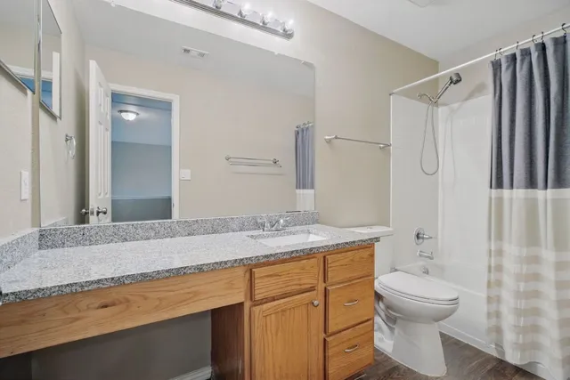 a bathroom with a granite countertop sink toilet and shower