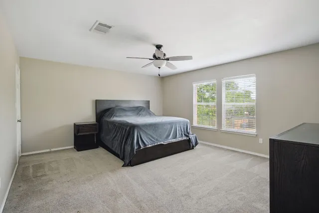 a bedroom with a large bed and a ceiling fan