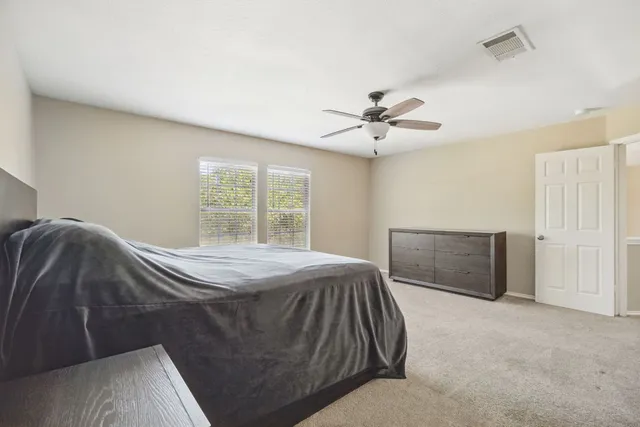 a spacious bedroom with a bed and a chandelier