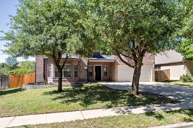 a tree in front of a white house
