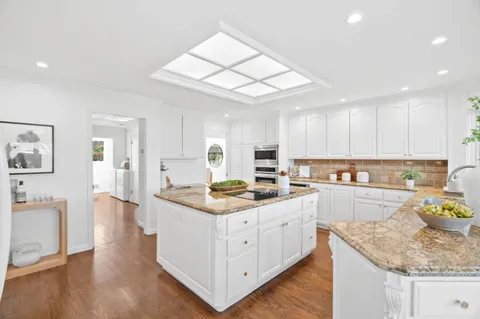 a kitchen with a stove a sink a refrigerator and cabinets