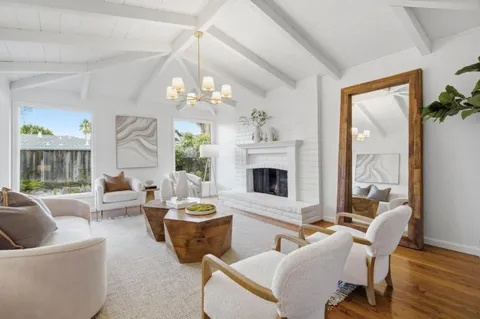 a living room with furniture a fireplace and a chandelier