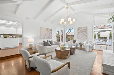 a living room with furniture a chandelier and a dining table