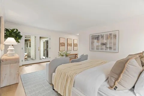 a spacious bedroom with a bed and wooden floor