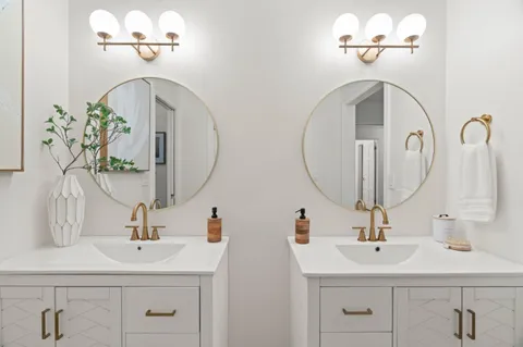 a bathroom with double vanity sinks and a mirror