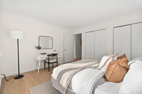 a bedroom with a bed a table window and chair