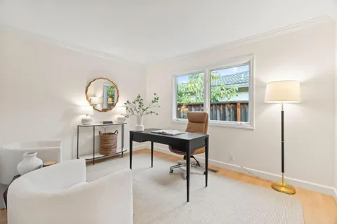 a living room with furniture a window and a potted plants on table