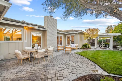 a view of a house with backyard sitting area and garden