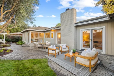 a view of a house with backyard and sitting area