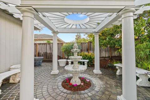 a porch with a table and chairs and potted plants