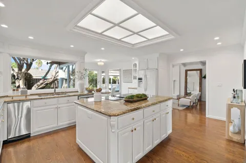 a kitchen with stainless steel appliances granite countertop a sink and dishwasher with wooden floor